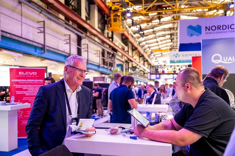 A conversation at an exhibition booth at a previous conference