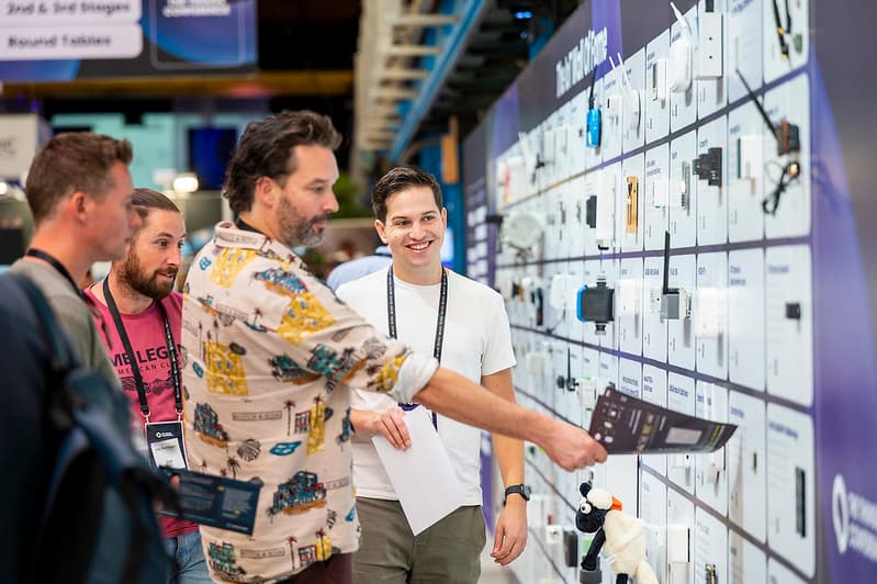 Attendees exploring devices on the Wall of Fame at a previous conference
